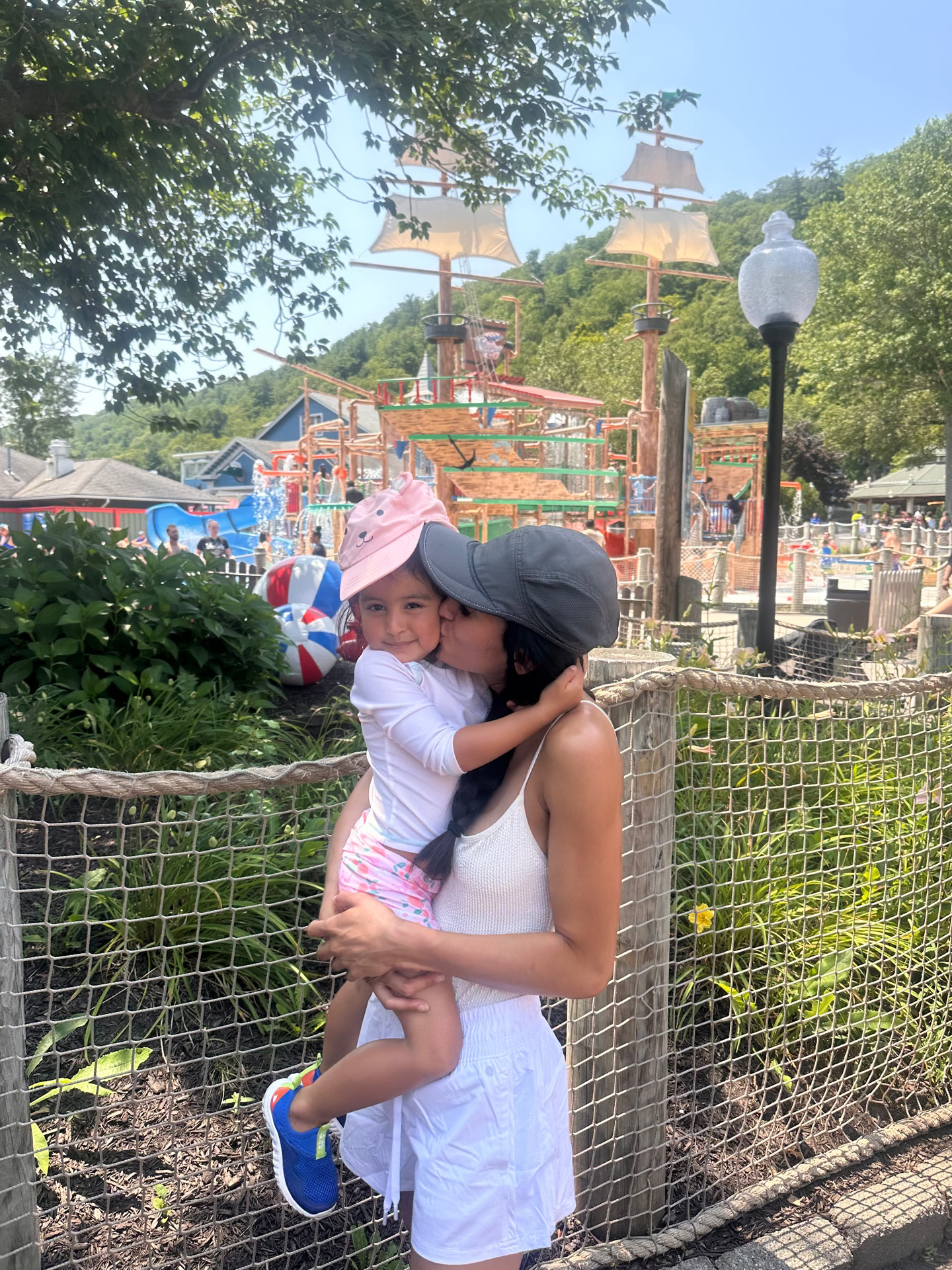 Mom holding her daughter at a Connecticut splash park on a summer day
